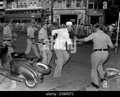 Polizei trifft Man mit Stöcken Unruhen Mumbai Maharashtra Indien Steuerung Stockfoto