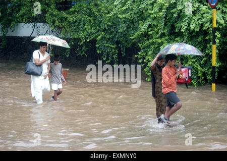 Menschen Frauen Kinder Regenschirm überflutete Straße Wasser regen Monsun Vidyavihar Bombay Mumbai Maharashtra, Indien Stockfoto