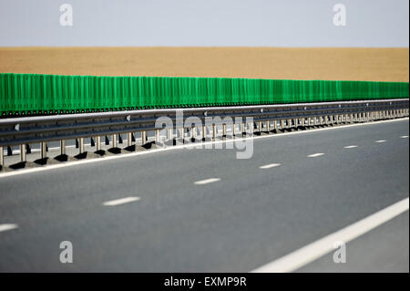 Leere zwei-spurige Autobahn mit Weizenfeld auf dem Hintergrund Stockfoto