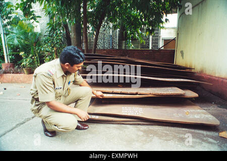 Polizist überprüft gestohlene eingefangene Stahlplatten, Bombay, Mumbai, Maharashtra, Indien, Asien Stockfoto