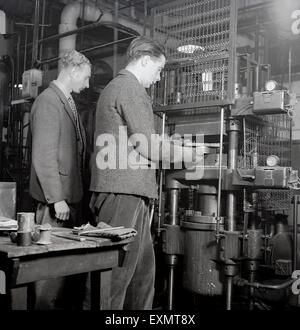 historische, engineering Student Betrieb eine Maschine mit Lehrer oder Betreuer auf der 1950er Jahre. Stockfoto