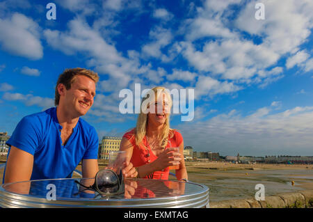 Ein junges Paar ein Getränk entlang dem Hafen Arm in Margate. Kent. UK Stockfoto