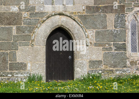 Cornwall, England. Kirche-Tür mit Frühlingsblumen. Stockfoto