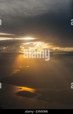 Sonnenstrahlen Shininhg unter einem bewölkten Himmel Gießen Licht auf das Land und den Fluss. Stockfoto