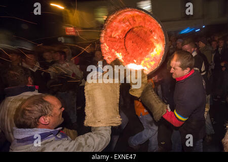 Endgültige Hogshead Lauf durchgeführt durch Menschenmassen auf dem Platz anlässlich Bonfire Night, 5 November, bei den Festspielen Tar Barrel schon St Mary, Devon, England Stockfoto