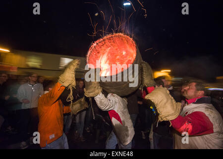 Endgültige Hogshead Lauf durchgeführt durch Menschenmassen auf dem Platz anlässlich Bonfire Night, 5 November, bei den Festspielen Tar Barrel schon St Mary, Devon, England Stockfoto