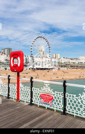 Brighton Beach mit Strandpromenade und Brighton Rad an einem sonnigen Sommertag betrachtet aus Palace Pier, East Sussex, Großbritannien Stockfoto