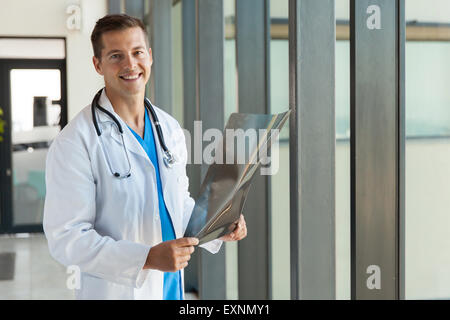 gut aussehende männliche Arzt mit Röntgenbild im Krankenhaus Stockfoto
