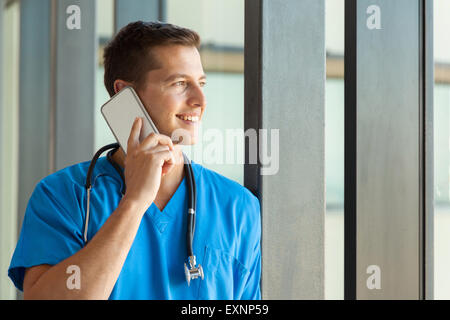 fröhliche Krankenpfleger telefonieren mit Handy in Klinik Stockfoto