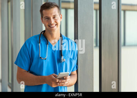 glückliche junge Ärztin hält Handy Stockfoto