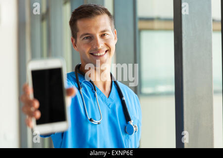 fröhliche männlichen Arzt hält Smartphone im Krankenhaus Stockfoto