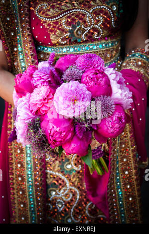 Bild von eine indische Bräute Händen mit bunten Blumenstrauß für die Hochzeit Stockfoto