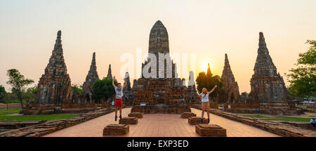 Zwei Touristen springen vor einem buddhistischen Tempel, Wat Chaiwatthanaram, Ayutthaya, Thailand Stockfoto