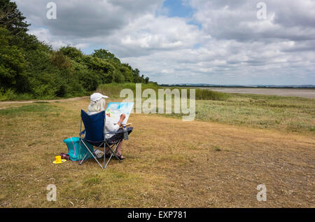 Artist sitzen Malerei die Landschaft in Pagham Harbour, West Sussex, England, Großbritannien Stockfoto