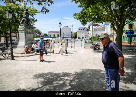 Menschen spielen die typicalFrench Partie Boule im Schatten der Statue von Jeanne d'Arc in Le Crotoy Stockfoto