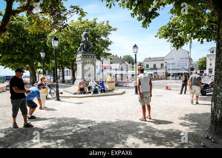 Menschen spielen die typicalFrench Partie Boule im Schatten der Statue von Jeanne d'Arc in Le Crotoy Stockfoto