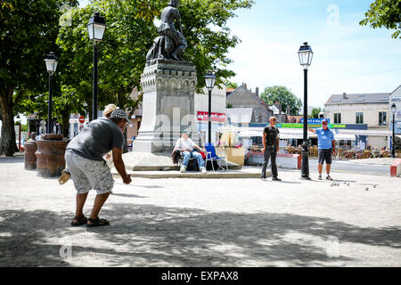 Menschen spielen die typicalFrench Partie Boule im Schatten der Statue von Jeanne d'Arc in Le Crotoy Stockfoto