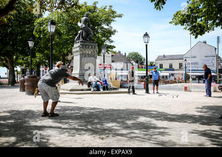 Menschen spielen die typicalFrench Partie Boule im Schatten der Statue von Jeanne d'Arc in Le Crotoy Stockfoto