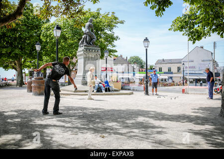 Menschen spielen die typicalFrench Partie Boule im Schatten der Statue von Jeanne d'Arc in Le Crotoy Stockfoto