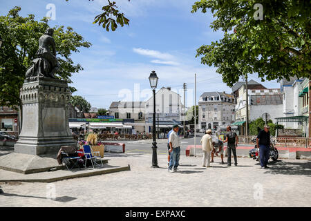 Menschen spielen die typicalFrench Partie Boule im Schatten der Statue von Jeanne d'Arc in Le Crotoy Stockfoto