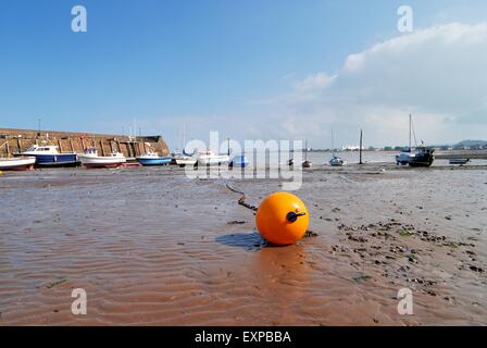 Minehead, Somerset, Großbritannien. Orangene Boje, die bei Ebbe im Schlamm im Hafen liegt. Stockfoto