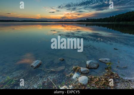 Wunderschöner See bei Sonnenuntergang Landschaft mit bewölktem Himmel im Wasser spiegelt. Polnischen See in Masuren Stockfoto