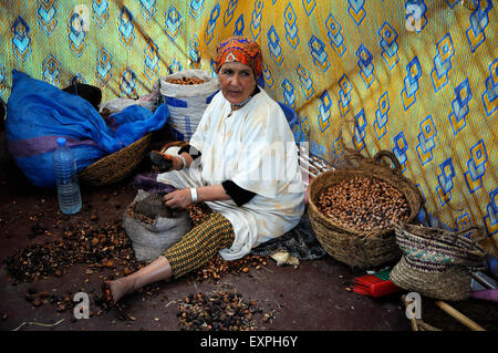 Berber Frau ist zwischen zwei Steinen weichen Zellstoff aus harten Argan Nuss von hand entfernen. Stockfoto