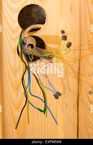 Neue Verkabelung und Ableitungen innerhalb einer Wand entstehen an einer Steckdose Standort in einem Holzhaus im Bau in Österreich Stockfoto