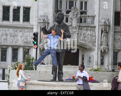 Westminster, London, UK. 16. Juli 2015. Ein Tourist genießt durch die Arme der Statue von Nelson Mandela im Parlament Square Westminster Kredit statt: Amer Ghazzal/Alamy Live-Nachrichten Stockfoto