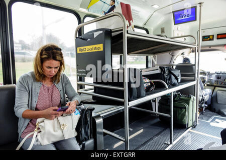 Saint St. Louis Missouri, Lambert-St. Louis International Airport, STL, Hertz, Autovermietung, Autovermietung, Shuttle, Bus, Bus, weibliche Frauen, Smartphone, Sittin Stockfoto