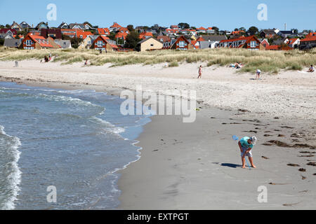 Surfen Sie an einem sonnigen Sommertag am Hundedest Beach in North Sealand, Dänemark. Junge Zeichnung in den nassen Sand mit einem Stock. Dünen, Hundestadt. Stockfoto