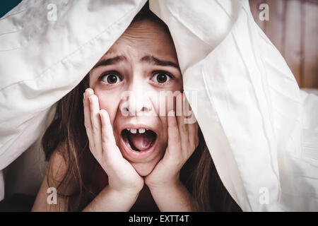 weißen kaukasischen junge Teenager-Mädchen versteckt sich unter seiner Decke und deckt Stockfoto