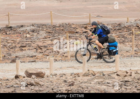 Radfahrer mit Gepäcktaschen und Zelt am Küstenweg in Spanien Stockfoto