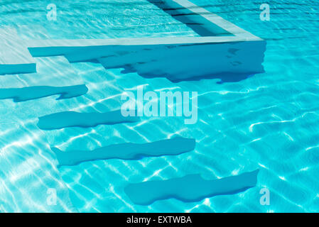 Unterwasser Schritte in einen glitzernden blauen Swimmingpool mit Reflexionen Stockfoto