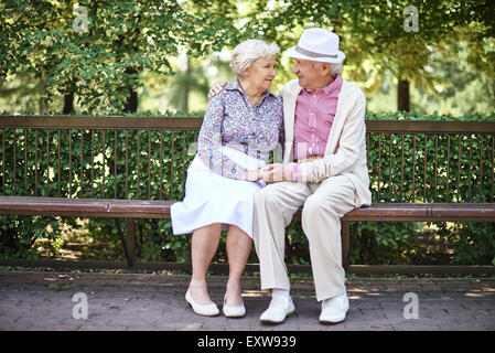 Gerne älteres Paar auf Bank sprechen Stockfoto