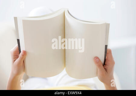 Junge Frau hält ein Buch, Stockfoto