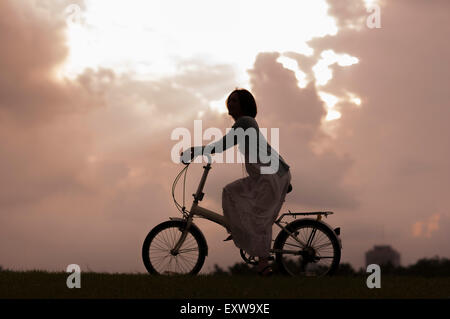 Junge Frau mit dem Fahrrad und wegsehen, Stockfoto