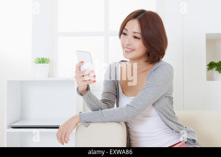 Junge Frau halten Handys und wegschauen mit Lächeln, Stockfoto