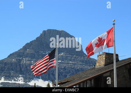 Amerikanischen und kanadischen Flaggen zeigen die volle Sterne und Streifen und Ahornblatt bzw. auf Silber Fahnenmasten Stockfoto