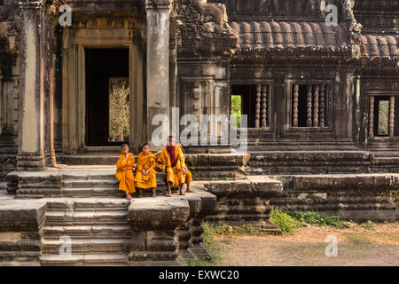 Mönche, Novizen, sitzt vor einer Bibliothek an der westlichen Zufahrt, Angkor Wat Tempel, Provinz Siem Reap, Kambodscha Stockfoto