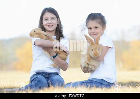 Zwei Kinder mit ihrem Kaninchen auf einer Wiese, Oberpfalz, Bayern, Deutschland, Europa Stockfoto