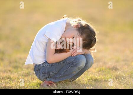 Mädchen mit einem Huhn auf Wiese, Oberpfalz, Bayern, Deutschland, Europa Stockfoto