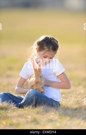 Mädchen mit ihrem Kaninchen auf Wiese, Oberpfalz, Bayern, Deutschland, Europa Stockfoto