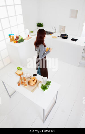 Junge Frau in der Küche stand, Stockfoto