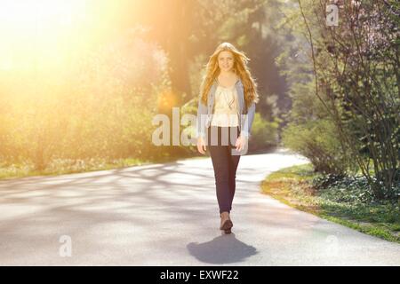 Junge Frau, die zu Fuß unterwegs im park Stockfoto