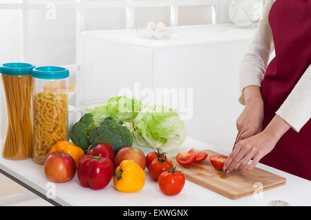 Junge Frau Schneiden von Gemüse in der Küche, Stockfoto