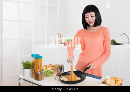 Junge Frau in der Küche mit Lächeln, Stockfoto
