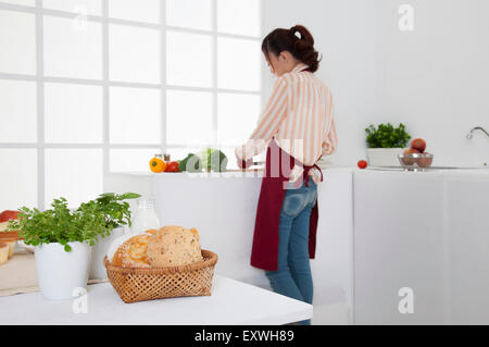 Junge Frau in der Küche und Schneiden von Gemüse, Stockfoto