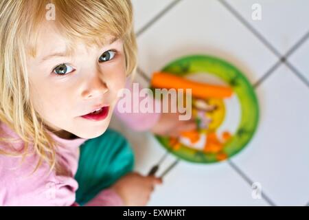 Mädchen schneiden Karotte Stockfoto