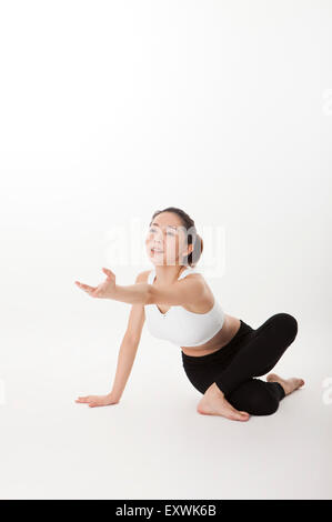 Frau, Yoga zu praktizieren und erreichen eine hand aus, Stockfoto